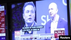 纽约证交所电视屏幕上显示的特斯拉首席执行官马斯克（左）亚马逊公司董事长兼首席执行官贝索斯的画像。（2022年4月11日）