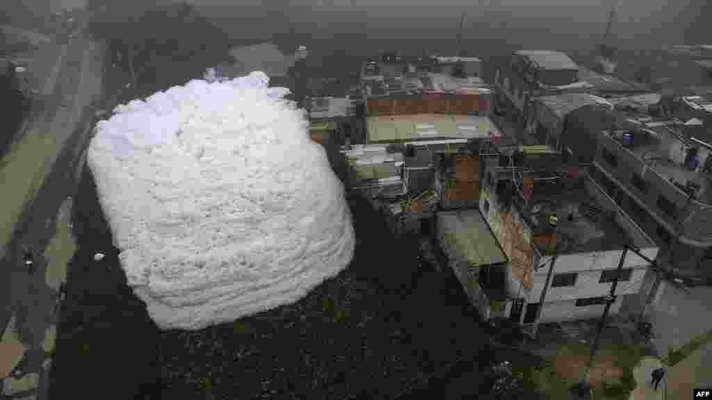 Pungent foam is seen in a polluted river and invaded the Los Puentes neighborhood, in Mosquera, west of Bogota, Colombia, April 26, 2022.