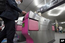 Penumpang melewati gerbang tiket di Stasiun Shibuya Tokyu Railways, Tokyo, Rabu, 20 April 2022. (AP/Eugene Hoshiko)