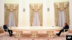 资料照片：俄罗斯总统普京在克里姆林宫隔着一张长桌与联合国秘书长古特雷斯会谈。(2022年4月26日)