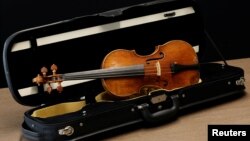 A rare 1736 violin by Italian luthier Guarneri del Gesu is displayed during a media preview at Aguttes auction house ahead of the violin's auction in Neuilly-sur-Seine, near Paris, France, April 26, 2022. (REUTERS/Benoit Tessier)