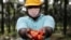 FILE - A worker holds palm oil fruits while posing for a picture at an oil palm plantation in Slim River, Malaysia August 12, 2021. Picture taken August 12, 2021.