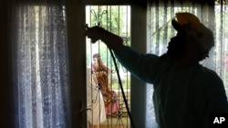 Ilustrasi: Seorang sukarelawan menyemprot dinding dengan obat nyamuk untuk menghentikan wabah malaria di daerah yang terendam air setelah tsunami di Banda Aceh, 17 Januari 2005.(AP/Wally Santana)