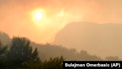 Pemandangan saat matahari terbenam di perbukitan yang dilanda kebakaran hutan di dekat desa Glogosnica, Bosnia. Muslim di Bosnia menghabiskan waktu jelang berbuka dengan cara mendaki bukit di kota Zenica. (Foto: AP)