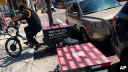 A worker sets to make a delivery on a bicycle in front of Gorillas mini-warehouse in the Williamsburg section of the Brooklyn borough of New York on Monday, April 12, 2022. (AP Photo/Tali Arbel)