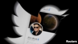Elon Musk twitter account is seen through Twitter logo in this illustration taken, April 25, 2022. 