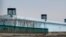 FILE - A person stands in a tower on the perimeter of the No. 3 Detention Center in Dabancheng in western China's Xinjiang Uyghur Autonomous Region on April 23, 2021. Human rights groups and Western nations have accused China of massive crimes against the Uyghur minority.