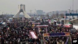 FILE -- Iranians attend an annual rally commemorating the anniversary of the 1979 Islamic revolution, on Azadi (Freedom) Street, while the Azadi tower is seen at rear left, in Tehran, Iran, Feb. 11, 2014. 