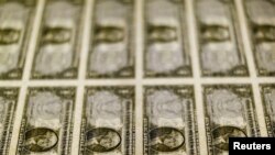 FILE - United States one dollar bills are seen on a light table at the Bureau of Engraving and Printing in Washington, Nov. 14, 2014. 