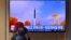 FILE - People watch a television screen showing a news broadcast with file footage of a North Korean missile test, at a railway station in Seoul, March 5, 2022.