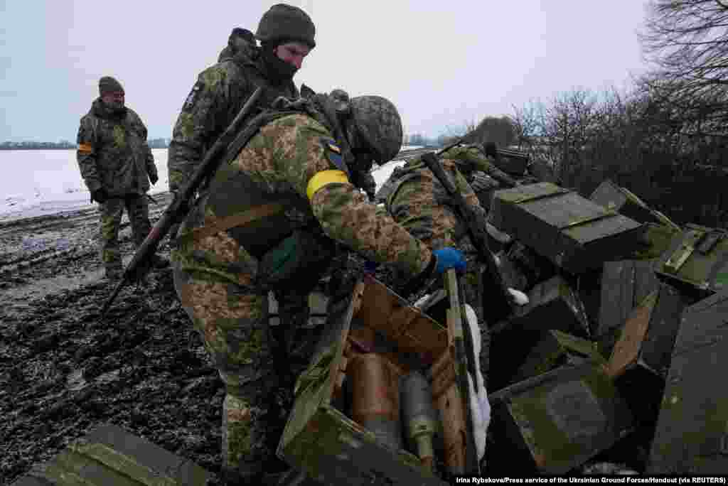 Ukrainian servicemen inspect ammunitions from destroyed Russian military vehicles in the Sumy region, March 7, 2022.