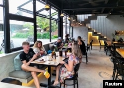 Pengunjung terlihat di dalam kafe yang sering dikunjungi orang Rusia di Kabupaten Badung, Bali, 8 Maret 2022. Pemerintah Indonesia bersiap meluncurkan visa digital nomad. Bali menyambut positif rencana ini. (Foto: REUTERS)