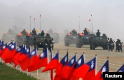Tentara mengendarai kendaraan militer mereka melewati bendera Taiwan selama latihan militer di Hsinchu, Taiwan tengah 27 Januari 2010. (Foto: Reuters)