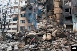 An apartment building is seen damaged after shelling in Kharkiv, Ukraine, Tuesday, March 8, 2022. (AP Photo/Andrew Marienko)