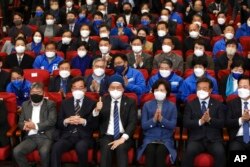 Members of the Democratic Party of Korea react as they watch a television report on an exit poll of the new president at the party's situation auditorium in the National assembly, in Seoul, South Korea, March 9, 2022.