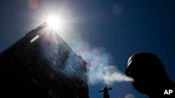 FILE - In this Jan. 18, 2012 photo, a smoker puffs on a cigarette in the central business district in Auckland, New Zealand.