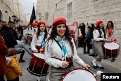 Members of a Palestinian scout band walk during Christmas celebrations, with Latin Patriarch of Jerusalem, Pierbattista Pizzaballa (not seen), in Bethlehem, in the Israeli-occupied West Bank, Dec. 24, 2022.