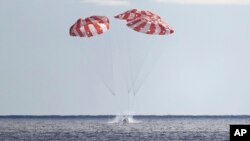 NASA's Orion capsule splashes down Sunday, Dec. 11, 2022, to conclude a dramatic 25-day test flight, as seen from aboard the U.S.S. Portland in the Pacific off Mexico. (Mario Tama/Pool Photo via AP)