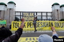 Seorang aktivis meneriakkan slogan-slogan saat protes pengesahan hukum pidana baru yang akan melarang seks di luar nikah, kumpul kebo antara pasangan yang belum menikah, menghina presiden, dan mengungkapkan pandangan yang bertentangan dengan ideologi nasional, di luar gedung DPR RI di Jakarta, 5 Desember 2022. (Foto: REUTERS/Willy Kurniawan)