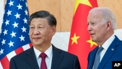 FILE - U.S. President Joe Biden stands with Chinese President Xi Jinping before a meeting at the G-20 summit in Bali, Indonesia, on Nov. 14, 2022. Sources said on Oct. 2, 2024, to expect a call between the two world leaders sometime in the coming days.