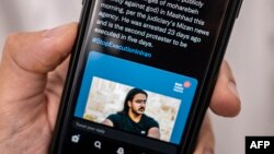 មនុស្សម្នាក់នៅក្នុង​រដ្ឋធានី​នីកូស៊ី​នៃ​ប្រទេសស៊ីប​មើល​ទូរស័ព្ទដៃ​នៅ​ថ្ងៃទី១២ ខែធ្នូ ឆ្នាំ២០២២ ដោយ​បង្ហាញ Tweet អំពី​ការប្រហារ​ជីវិត​ដែល​ប្រកាស​ដោយ​អាជ្ញាធរ​អ៊ីរ៉ង់​លោក Majidreza Rahnavard ដែលជា​ការប្រហារ​ជីវិត​អ្នកទោសទី២ ដែល​ជាប់​ពាក់ព័ន្ធ​នឹង​ការតវ៉ា​អស់​រយៈពេល​ជិត​បីខែ​មកនេះ។