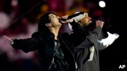 Personil BTS Jung Kook (kiri), bersama penyanyi Qatar, Fahad Al Kubaisi di acara pembukaan Piala Dunia 2022 (dok: AP/Manu Fernandez)