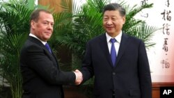 អនុ​ប្រធាន​ក្រុមប្រឹក្សា​សន្តិសុខ​របស់​ប្រទេស​រុស្ស៊ីលោក Dmitry Medvedev (ឆ្វេង) និង​ប្រធានាធិបតី​ចិន​ លោក Xi Jinping ចាប់​ដៃ​គ្នា​នៅ​ក្នុង​ជំនួប​របស់​ពួកគេ​នៅ​ទីក្រុង​ប៉េកាំង ប្រទេស​ចិន ថ្ងៃទី ២១ ខែធ្នូ ឆ្នាំ២០២២។ 