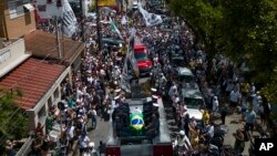 Sekey defen vedet foutbol Pele ki vlope ak drapo Brezilyen an ak klib foutbol Santos FC a pase devan stad Vila Belmiro a nan vil Santos, Brezil, 3 Janvye, 2023.