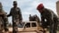 FILE - Somali National Army Personnel climb in to pickup trucks at Baidoua airport in Baidoa, Somalia, on Nov. 9, 2022. 