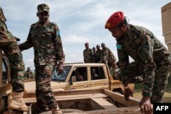 FILE - Somali National Army Personnel climb in to pickup trucks at Baidoua airport in Baidoa, Somalia, on Nov. 9, 2022.