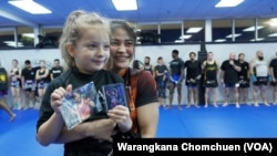 Stamp Fairtex poses with a young fan at a Muay Thai seminar at Impact Martial Arts Academy in Virginia, October, 2022.