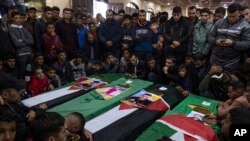FILE-Mourners gather around the coffins of Palestinian migrants who died off the Tunisian coast, during their funeral at a mosque in Rafah in the southern Gaza Strip, Dec. 18, 2022.