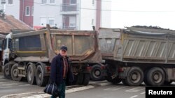 Muškarac prelazi ulicu u blizini blokade u sjevernom dijelu etnički podijeljene Mitrovice, Kosovo, 27. decembar 2022. REUTERS/Miodrag Draškić