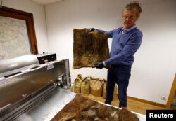 Patrick Janssen, salah satu pendiri organisasi Dung Dung, menunjukkan ubin yang terbuat dari rambut manusia daur ulang yang digunakan untuk menyerap zat kimia pencemar dalam air, di Waremme, Belgia 8 Desember 2022. (REUTERS/Yves Herman)