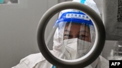 A health worker waits for people to take swab samples to test for COVID-19 in the Jing'an district in Shanghai on Dec. 23, 2022.