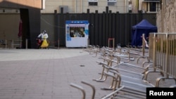 身穿防护服的工作人员在等候上海市民前来做新冠核酸检测。（2022年12月22日）