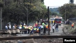 Des gens se rassemblent près d'un camion incendié à l'entrée du pont endommagé où un pétrolier a explosé à Boksburg près de Johannesburg, Afrique du Sud, le 24 décembre 2022.