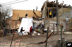 Volunteers on Jan. 6, 2023, help reconstruct a house destroyed during a Russian attack on Dec. 31, 2022, in Kyiv, Ukraine. Russian President Vladimir Putin ordered Moscow's forces to observe a 36-hour cease-fire in Ukraine this weekend for the Russian Orthodox Christmas holiday, but Ukrainian President Volodymyr Zelenskyy questioned the Kremlin's intentions.