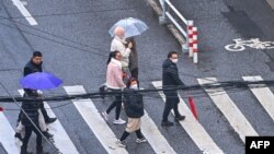 People walk on a street in the Jing'an district in Shanghai on Dec. 3, 2022. 