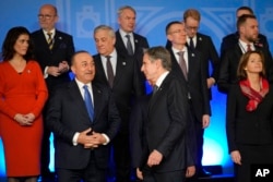 U.S. Secretary of State Antony Blinken, center, walks by Turkey's Foreign Minister Mevlut Cavusoglu before a NATO family photo in Bucharest, Romania, Nov. 29, 2022.