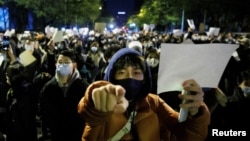 北京民众走上街头举起白纸游行抗议当局严厉的防疫封控措施。（2022年11月27日）