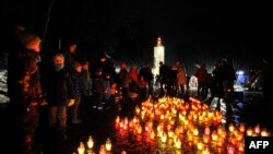 Local residents light candles during ceremony at a monument of the victims of the Holodomor, Ukrainian for "death by starvation," in Kyiv, Nov. 26, 2022, amid the Russian invasion of Ukraine.