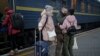 Ukrainian soldier Vasyl Khomko, 42, meets his daughter Yana and his wife Galyna, left, at the train station in Kyiv, Dec. 31, 2022. 