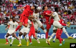 Pemain Korea Selatan Kim Min-jae, kiri, dan pemain Ghana Andre Ayew, kanan, melompat untuk menyundul bola selama pertandingan sepak bola grup H Piala Dunia antara Korea Selatan dan Ghana, di Stadion Education City di Al Rayyan, Qatar, Senin, 11 November 2018. 28 Agustus 2022. (Foto: AP/Lee Jin-man)