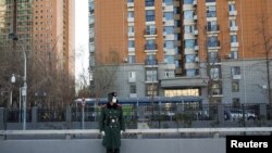 A member of the Chinese People's Armed Police Force wears a face mask as he keeps watch on a street amid COVID-19 outbreaks in Beijing, Dec. 1, 2022.