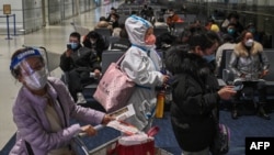 A passenger wearing protective clothing amid the Covid-19 pandemic waits to board a domestic flight at Shanghai Pudong International Airport in Shanghai on Jan. 3, 2023. 