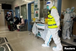 湖北省武汉同济医院内的保安在注视医护人员护理新冠病人。（2023年1月1日）