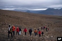 In this file photo, people climb to the top of what once was the Okjokull glacier, in Iceland, Sunday, Aug. 18, 2019. (AP Photo/Felipe Dana, File)