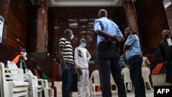 Sidi Mohamed Kounta, center, and Hantao Ag Mohamed Cisse stand after their sentence to life imprisonment, in Abidjan, Dec. 28, 2022.