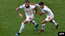 Iran's Roozbeh Cheshmi, left, celebrates scoring his team's first goal during its 2022 World Cup Group B soccer match against Wales at the Ahmad Bin Ali Stadium in Al-Rayyan, Nov. 25, 2022.